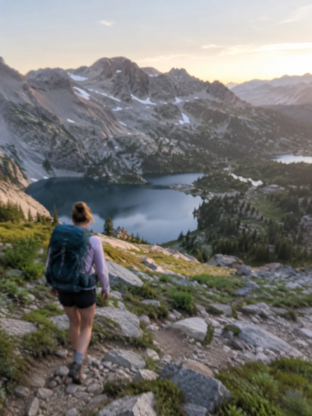 Slightly blurry photo of a hiker above an alpine lake